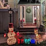 Green door with a wreath on it and lighted snowman, reindeer, and presents on Christmas Tree Lane in Alameda