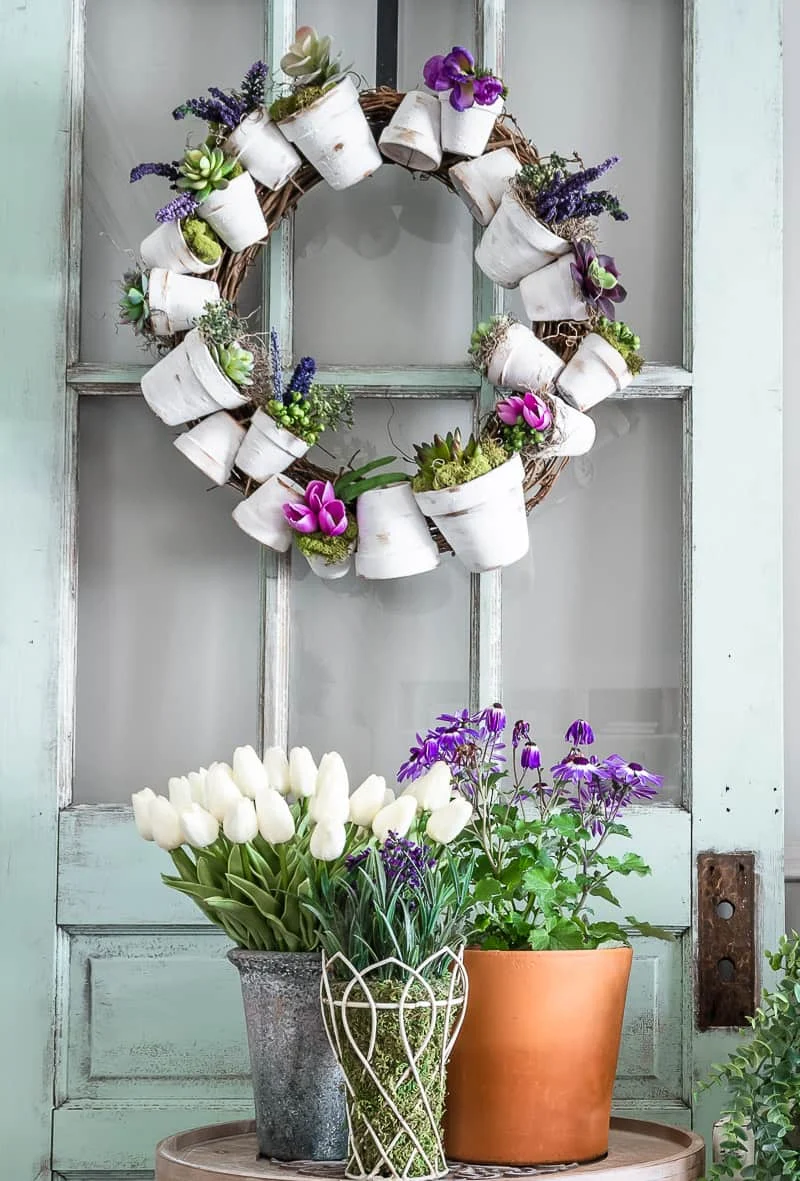 white aged terracotta pot wreath with succulents and purple Spring flowers