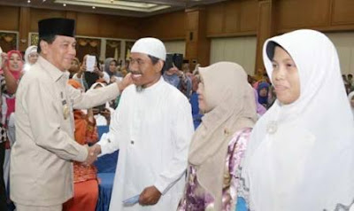 Bupati Rohul Drs H Achmad MSi bersalaman dengan para guru usai menyerahkan secara simbolis buku rekening bank BRI kepada guru yang akan menerima dana kesra guru agama di Convention Hall Islamic Center Pasirpengaraian, Jumat (4/12/2015).