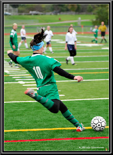 girl in green playing soccer