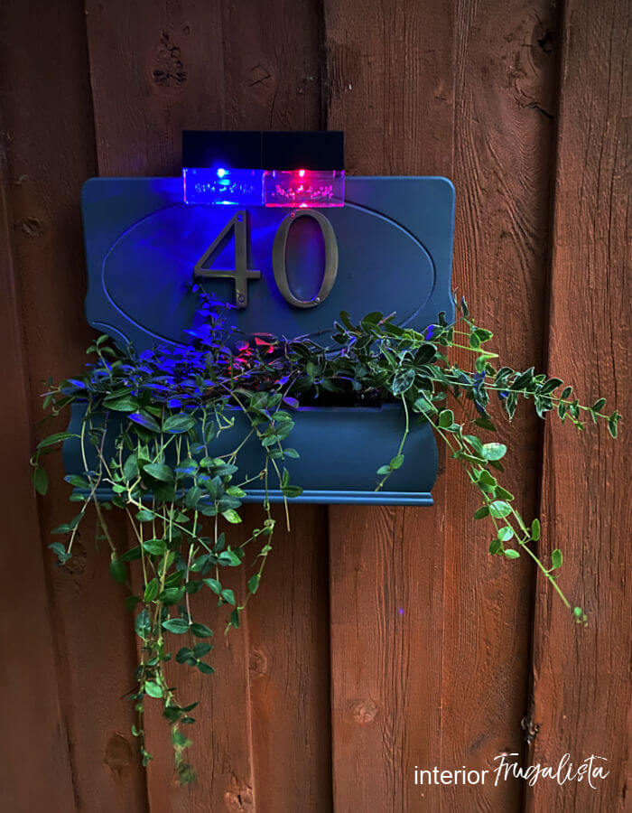 How to build a house number planter box that is backlit at night with solar lights, made from a repurposed Bombay-style jewelry box and wooden plaque.