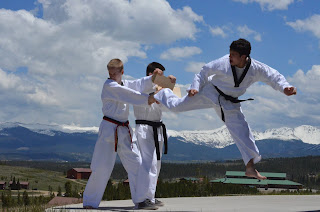 Martial arts black belt instructor breaking a board