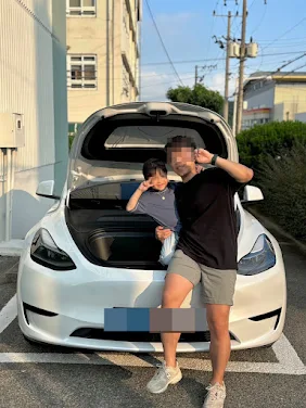 Korean dad and son posing in front of Tesla Model Y for blog review
