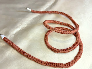 Power cord covered in burnt orange yarn