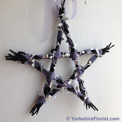  black wood star with lilac ribbon and metallic silver leaves