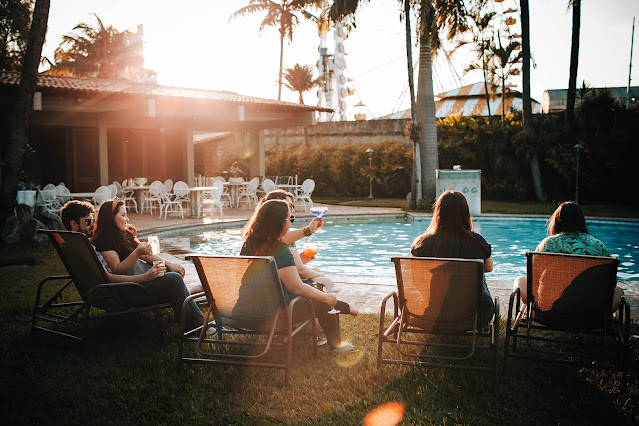 https://www.pexels.com/photo/people-sitting-on-sunloungers-near-swimming-pool-4279124/