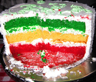Inside of cake layered with red, green, and yellow cakes and white frosting
