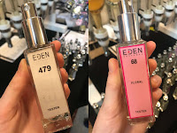 The two Eden Perfumes, 479 in glass  bottle with white label and 68 in glass bottle with pink label, on my Christmas wish list, pictured in front of the selection of perfumes at one of the vegan food fairs.