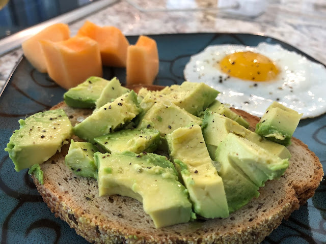 Avocado toast with egg and cantalope on a plate