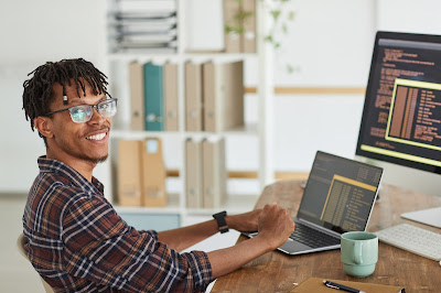 A person with dreads coding