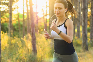 Lady smiling while running in a forest