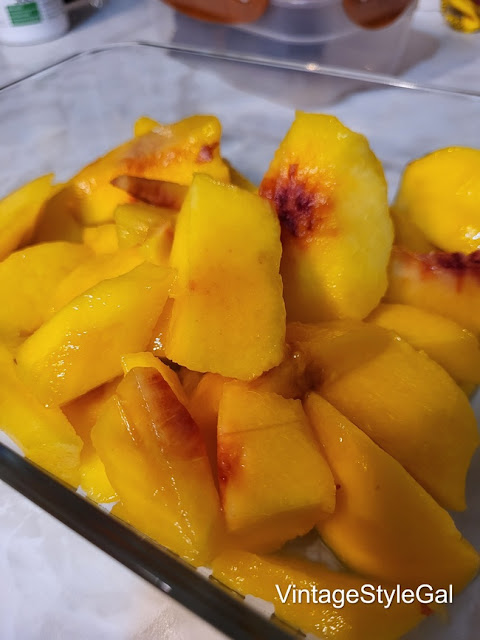 peeled and sliced peaches in glass dish