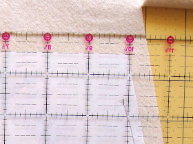 Place acrylic ruler on top of fabric, adding seam allowance of 1/2 inch to all sides