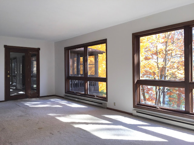 Minnesota lakeside mountain cabin home living room renovation after with all white paint, floor to ceiling windows, and french door