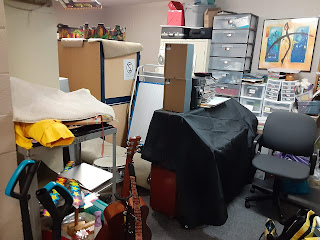 Room filled with cabinets, a piano, desk items, and a desk chair