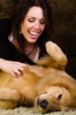 A woman gives tummy rubs to a relaxed Golden Retriever