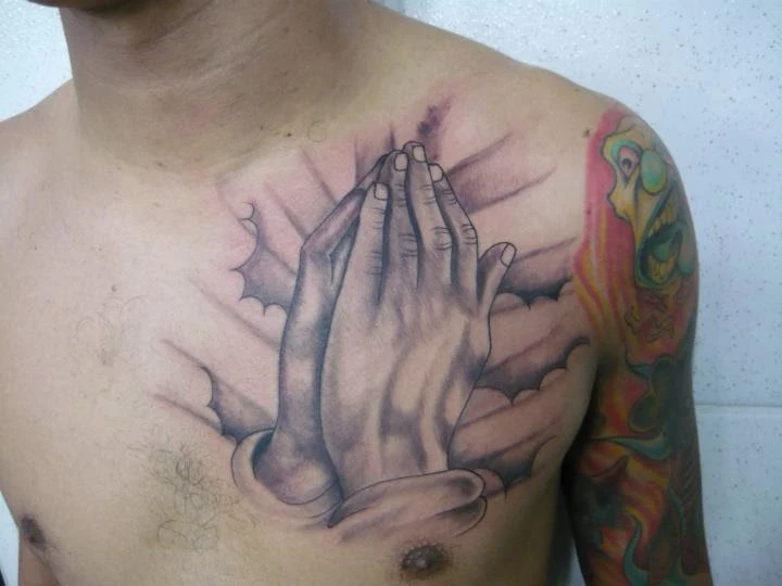 Tattoo no peito mãos que oram 