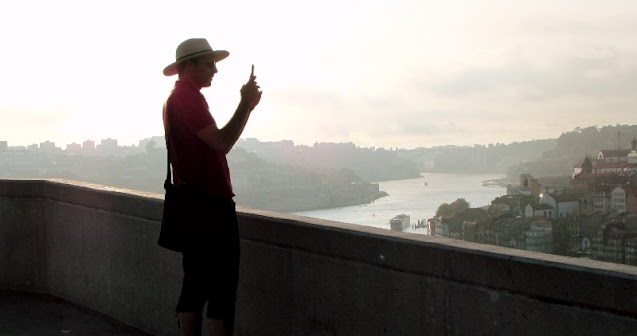 Homem de chapéu fazendo uma foto a partir do Jardim do Morro