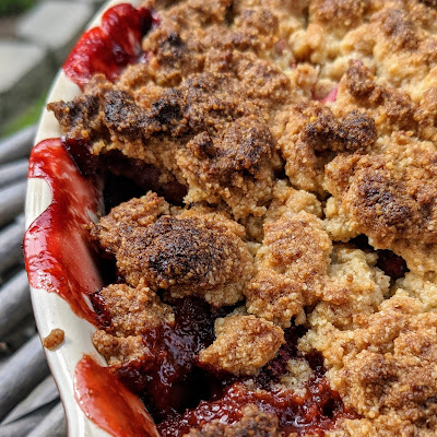 Overhead view of crumble, cropped to one side, red juices and browned crumbles.