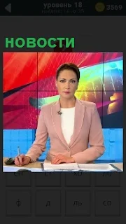 На экране женщина за столом с ручкой и записями, ведущая программу новости 