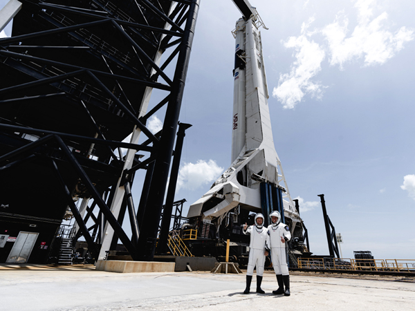 At Kennedy Space Center's Launch Complex 39A, NASA astronauts Douglas Hurley and Robert Behnken pose with the Falcon 9 rocket that sent them on their way to the International Space Station...on May 30, 2020.
