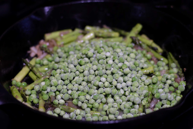 The frozen peas added to the cast iron skillet.