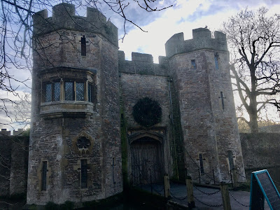 Photo of gatehouse to Bishop's PAlace, Wells - two turrets and a large wooden door in the cnetre