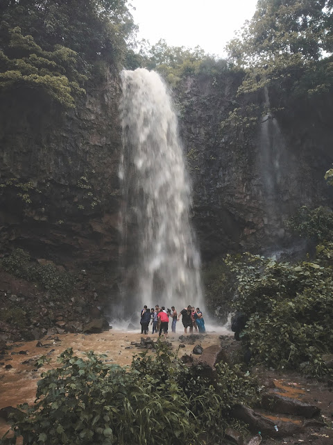 People stand near a beautiful waterfall