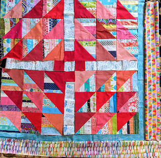 Components of The Square Deal are arranged with a narrow turquoise inner border and two choices for the outer border. Both are multi-colored. One is made printed of small rectangles and the other of small triangles.