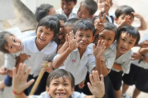 Many children in their school uniform showing their hands cheerfully