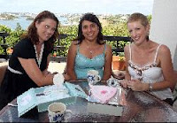 Tania Targett, Marina Sousa, & Pia Hopkins looking at the scrapbook Tania put together to remember her son Jacks brief life.