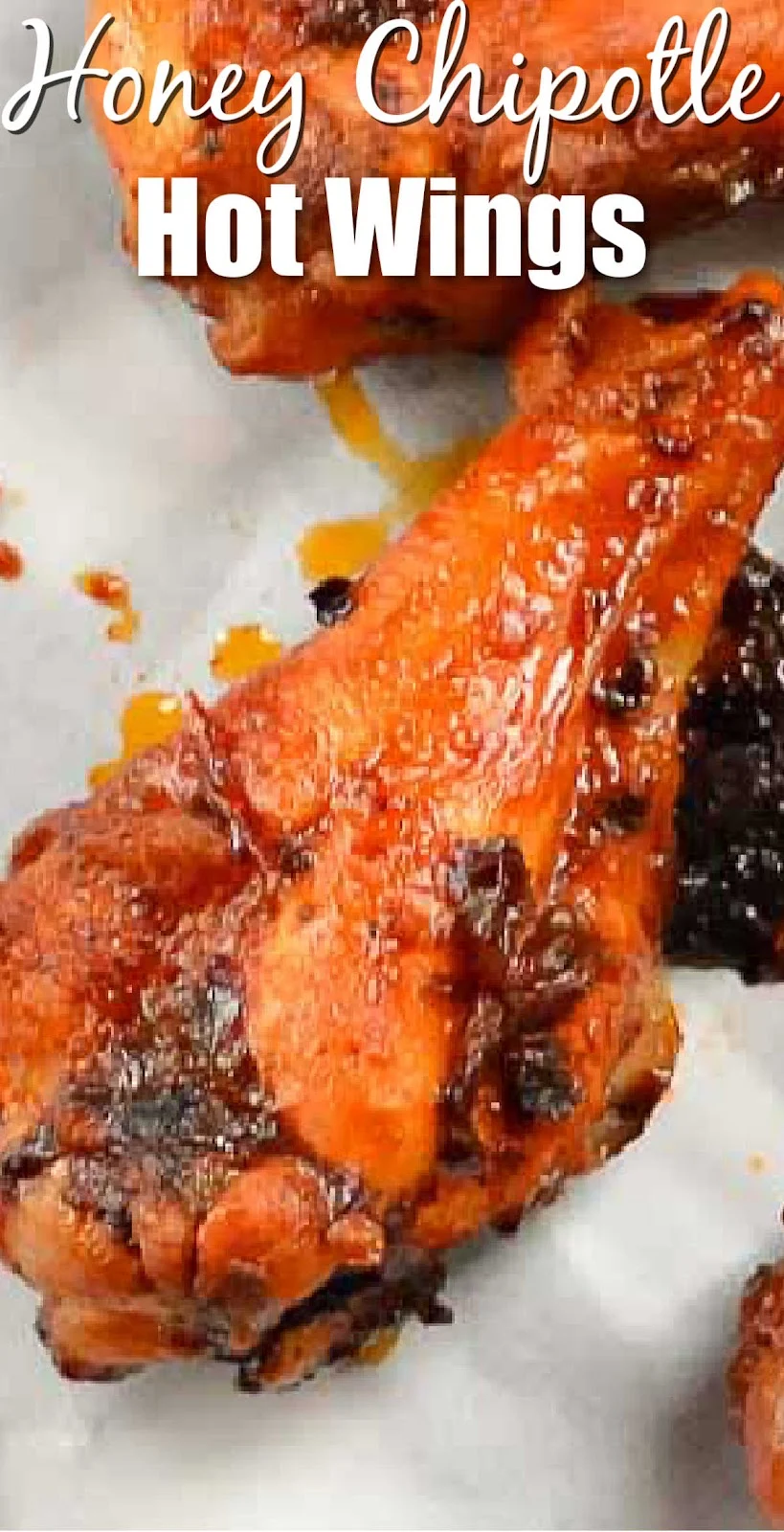 A down shot of a Honey Chipotle Hot Wings on a white piece of parchment paper. White text at the top Honey Chipotle Hot Wings.