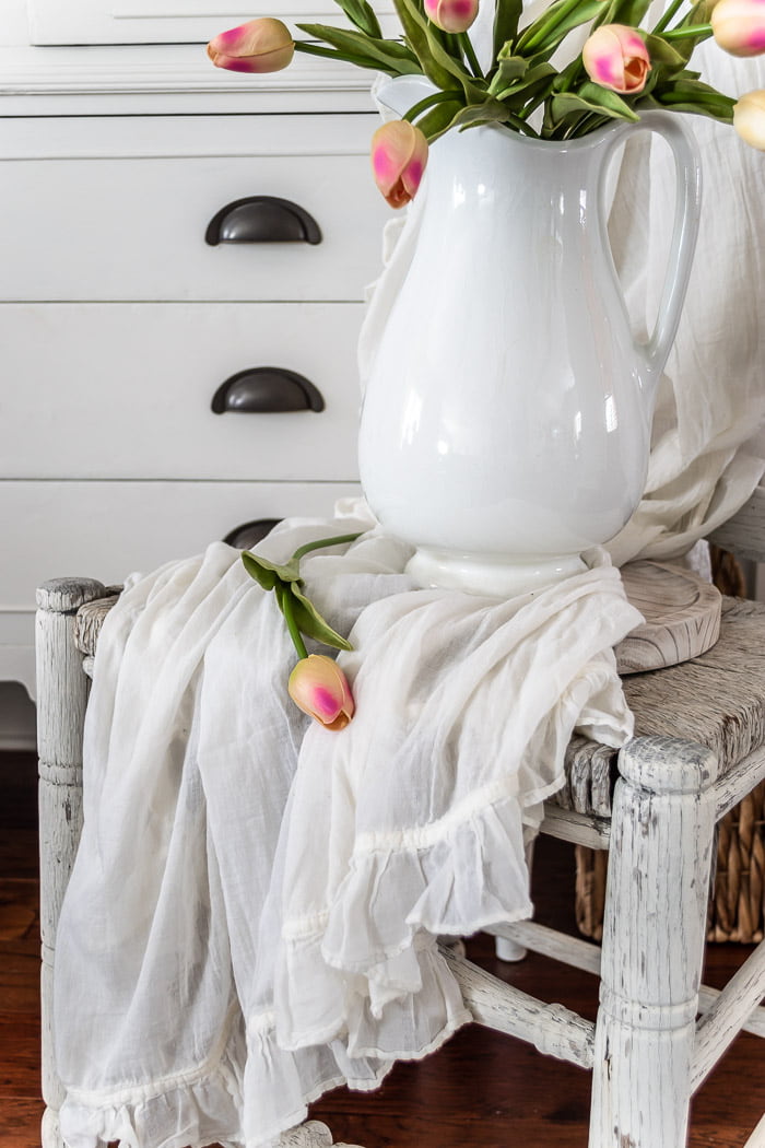 white ironstone pitcher, pink tulips, white dresser, rustic chair