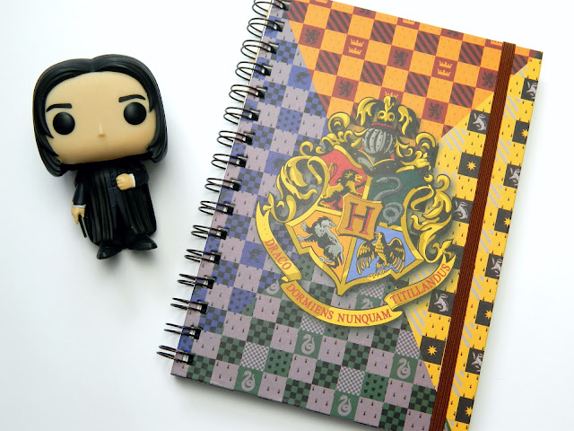 A photo of a Harry Potter notebook with the Hogwarts Crest on the cover and a figure of Severus Snape