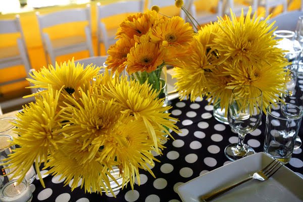 Table centerpieces made out of yellow spidermums and yellow gerberas