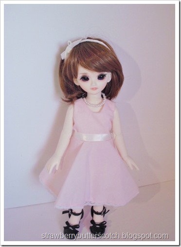 A pink vintage style dress set for a doll.