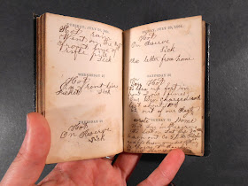 An open book of handwritten entries attached to printed dates.