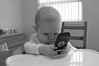 Child learning to speak playing on cellphone.