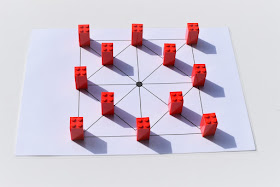 na zdjęciu plansza do gry w samotnika, na planszy stoi dwanaście pionków w pozycji wyjściowej czyli wolne miejsce centralne