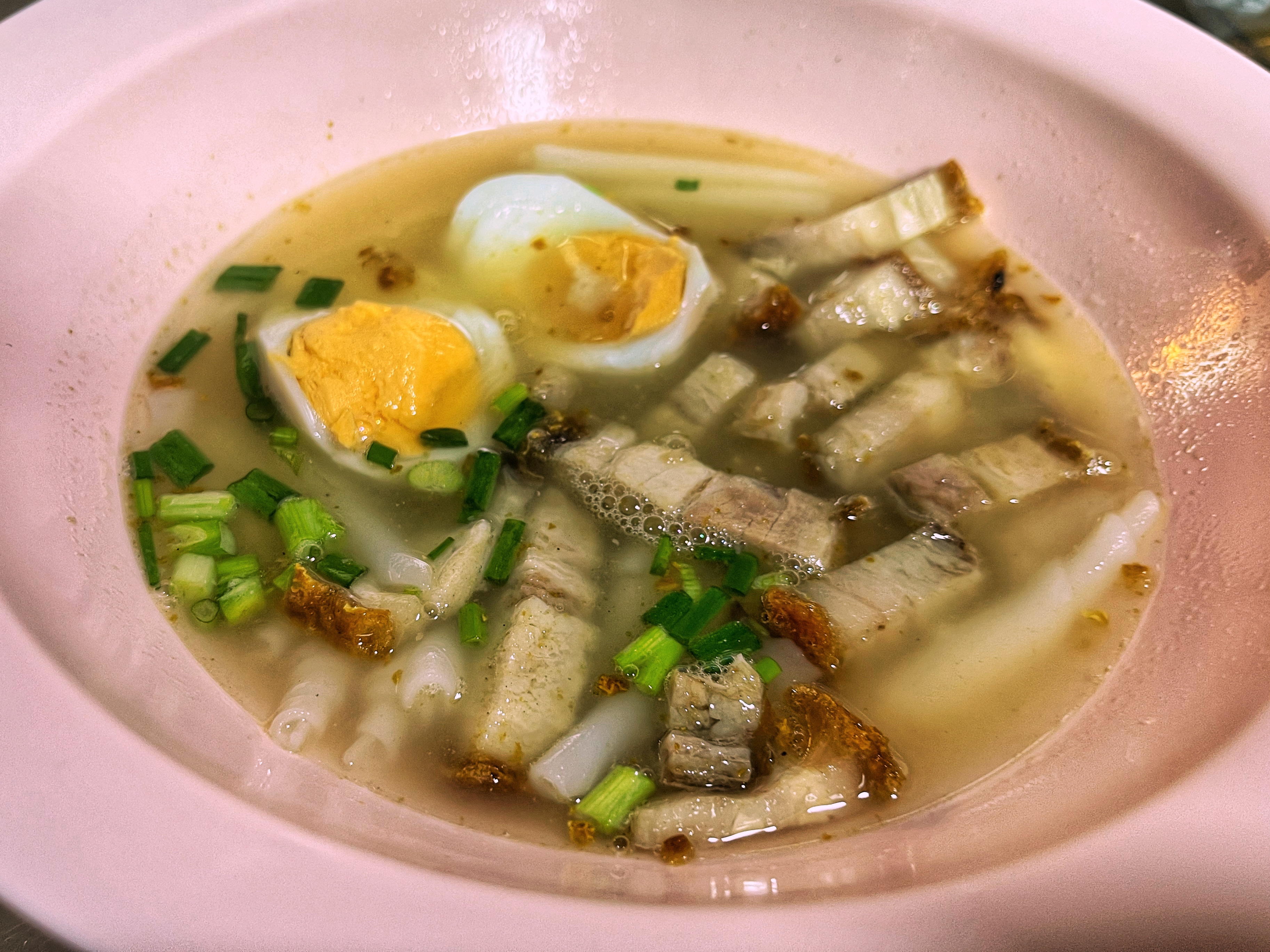 a bowl of peppery kuay jap noodles with crispy pork in Bangkok, Thailand