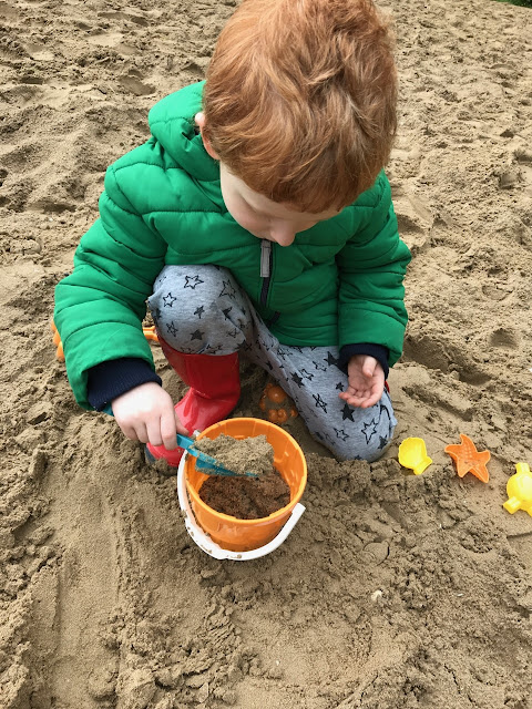 A little boy making sandcastles