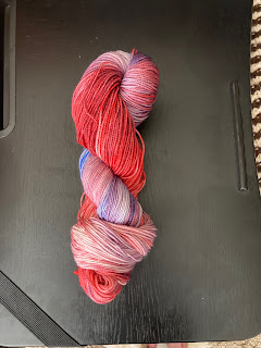 a skein of yarn shading from red to blue, passing briefly through purple. Looks like one of those red/white/blue popsickles you can get from ice cream trucks.