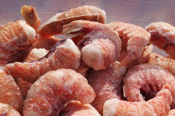 how to clean and cook rock shrimp these are on a white plate and butterflied with herb sauce