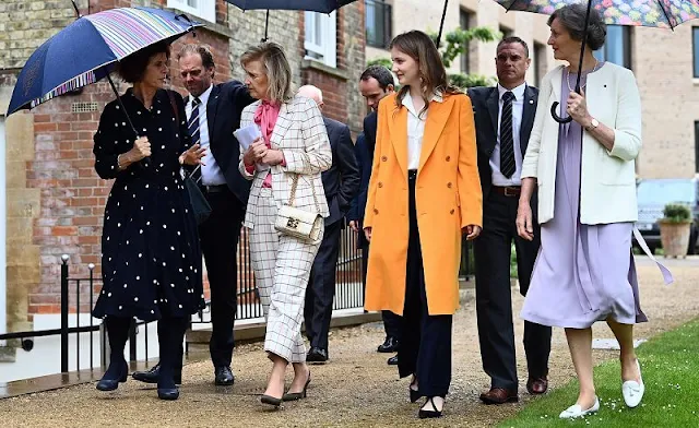 Crown Princess Elisabeth wore a yellow wool cashmere coat, and gold earrings. Zara trousers and silk shirt. Princess Astrid wore a suit