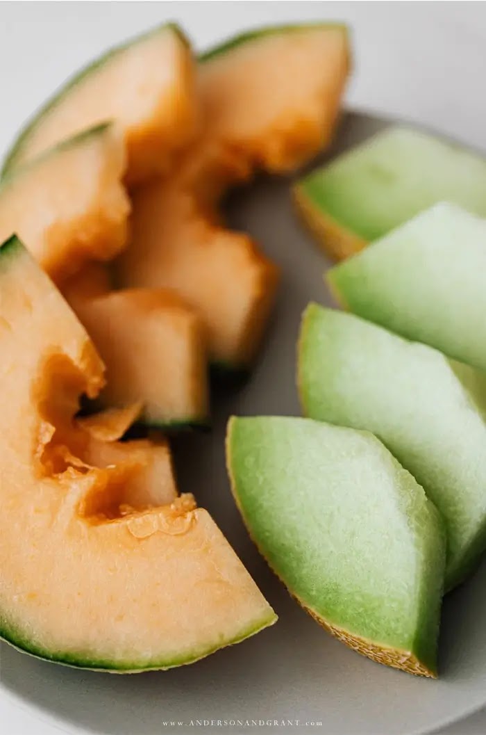 Slices of cantaloupe and honeydew on white plate