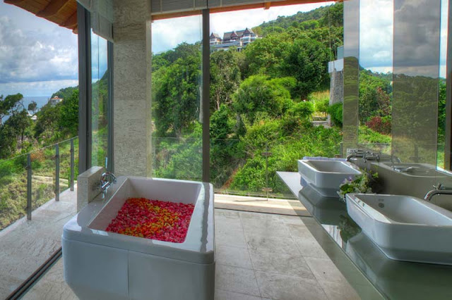 Modern corner bathroom with ocean and vegetation view 