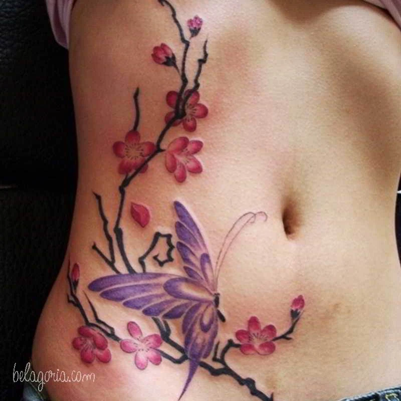 Tatuajes de flores y mariposas en la cintura de una mujer