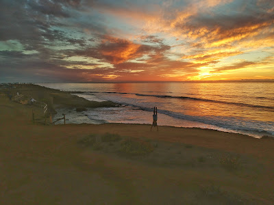 Tim doing handstand at Sunset Cliffs with sunset behind him