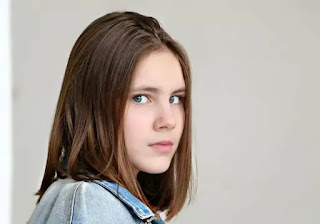 A girl in white dress and white background looking forward- sad girl dp