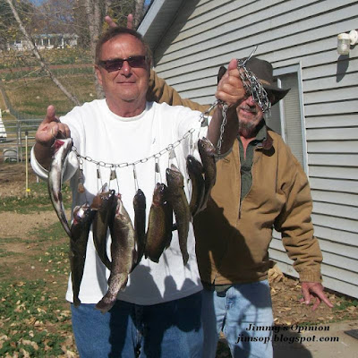 Cindy's Uncle Larry showing off a stringer of fish while her Dad Ray unknowingly gives him the Bunny Ears from behind with his fingers